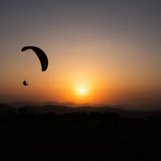 Young Man Paragliding during sunset - Camping and Paragliding in Bir Billing