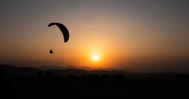 Young Man Paragliding during sunset - Camping and Paragliding in Bir Billing
