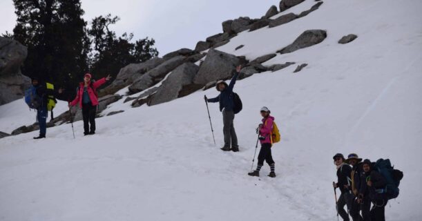 Adventurers climbing a snowy peak, enjoying the serene beauty of the mountain landscape.