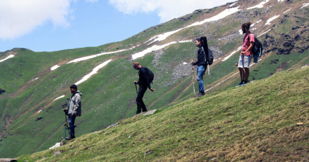 Four friends trekking along a mountain trail.