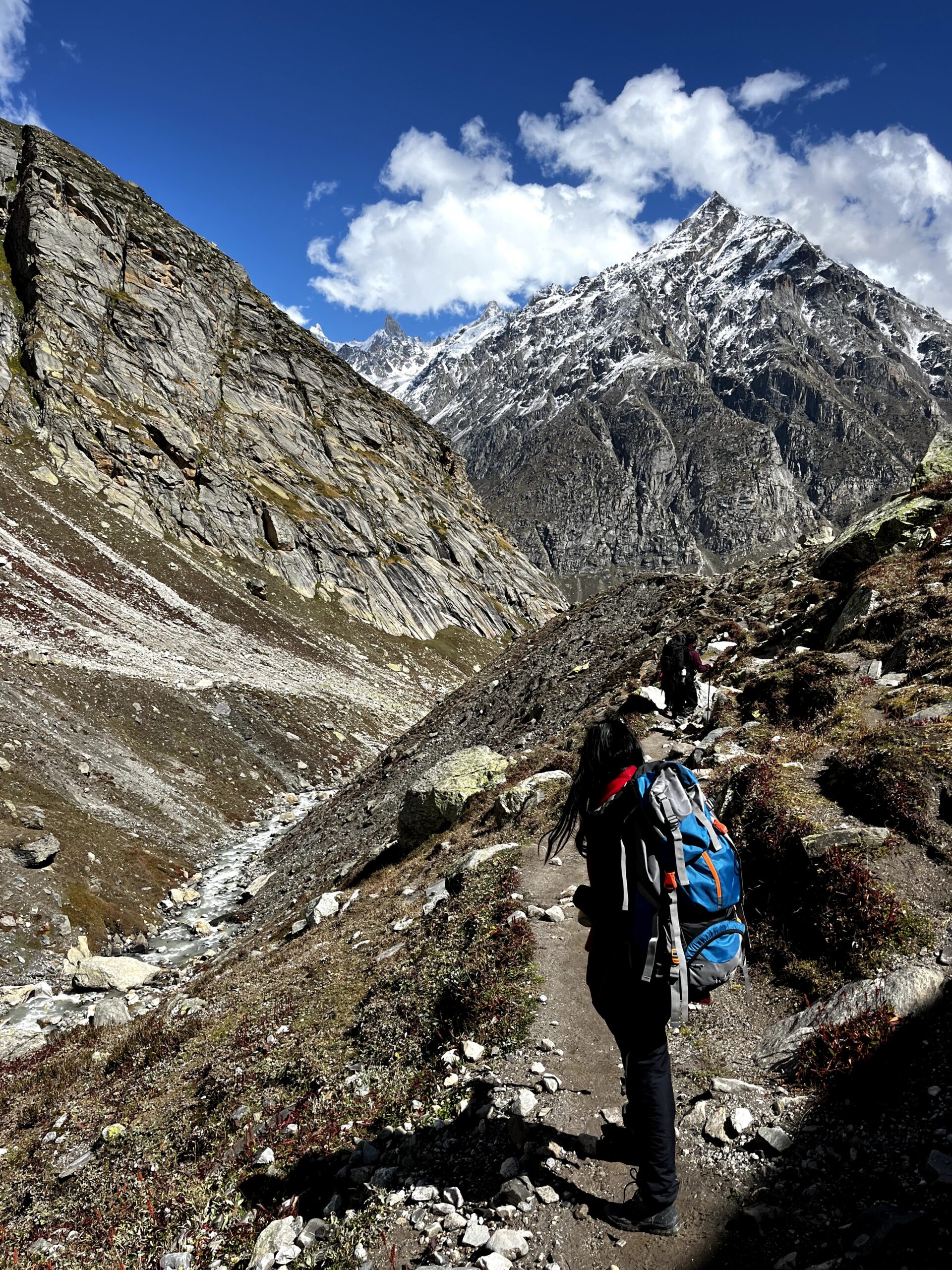 Trekker hiking on the Hampta Pass Trek trail with Himalayan mountains