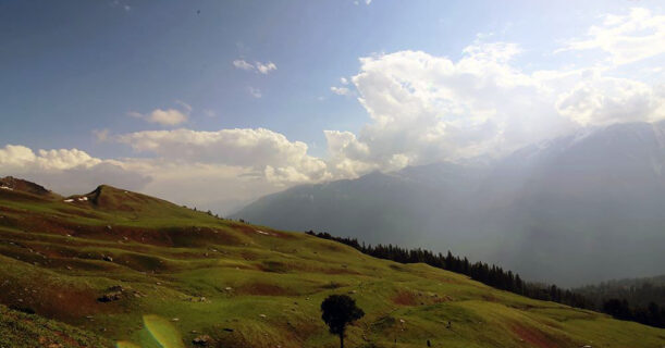 Scenic view of mountains and grassy hills from the hilltop.