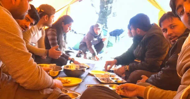 A bunch of individuals enjoying a meal inside a tent.