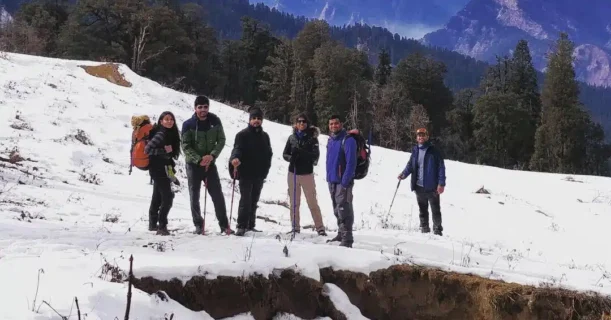 A gathering of people stands together on a snowy mountain, surrounded by a breathtaking winter landscape