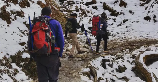 Adventurers trekking through a snowy landscape, surrounded by the stunning peaks of Nepal's Himalayas.