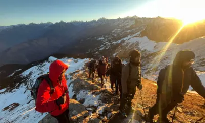 Group of trekkers celebrating their summit at Kedarkantha Peak.