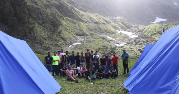 A group of individuals positioned in front of tents, representing unity and the spirit of outdoor exploration.