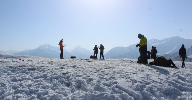 A group of masses standing on a snowy mountain peak, enjoying the breathtaking view.