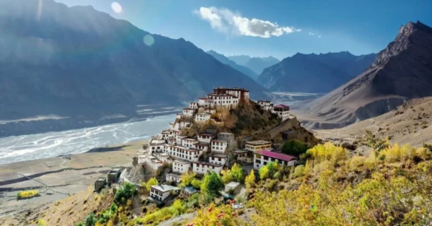 Ancient monastery perched on a hill overlooking a river valley in the himalayas.