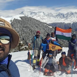 Trekkers pose with flag in snow
