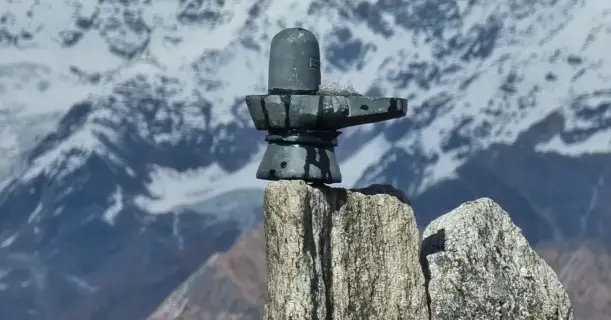 Gray Shiva Lingam on a mountain with snow