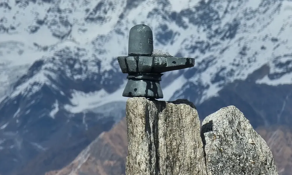 Gray Shiva Lingam on a mountain with snow