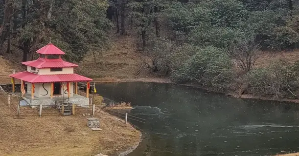 Small Hindu temple near forested lake on trekking route
