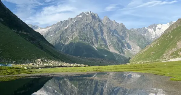 Reflections of snow-capped mountains in an alpine lake near Kara campsite on the Pin Bhaba Pass trek