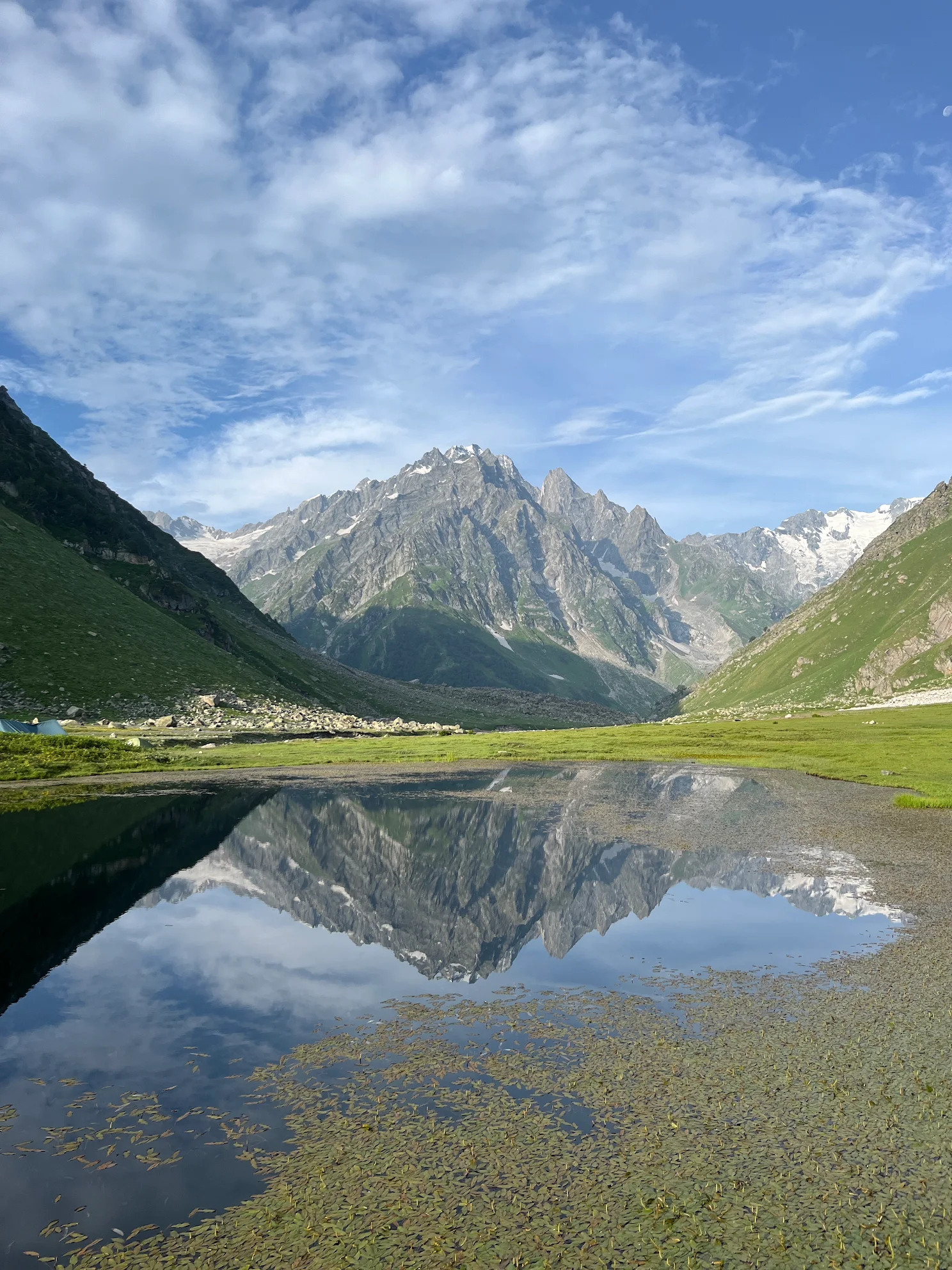 Reflections of snow-capped mountains in an alpine lake near Kara campsite on the Pin Bhaba Pass trek
