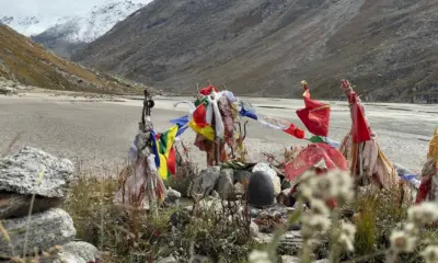 Close-up of sacred prayer flags and Shiva lingam at Mantalai Lake during the Pin Parvati Pass Trek in Himachal Pradesh