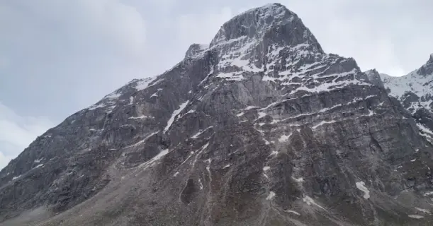 Odi Thach campsite with a towering rocky mountain in the background on the Pin Parvati Pass trek.