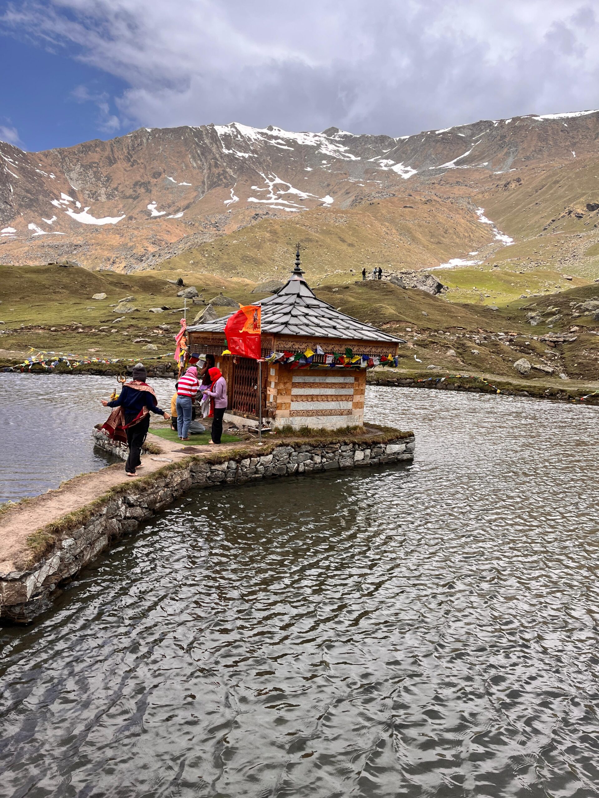 Krishna temple on the banks of Yulla Kanda Lake surrounded by snow-capped Himalayan mountains in Himachal Pradesh