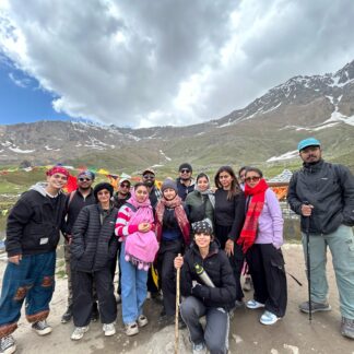 Travelers resting at Yulla Kanda Lake during a Himalayan trek in Kinnaur Valley