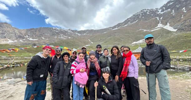 Travelers resting at Yulla Kanda Lake during a Himalayan trek in Kinnaur Valley