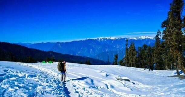 Person walking on snow with mountains