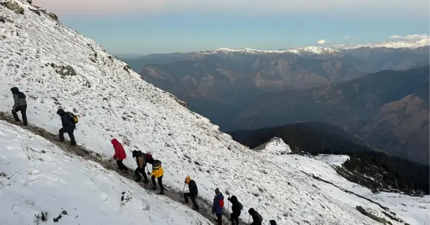 Hikers climbing a snowy mountain in winter gear