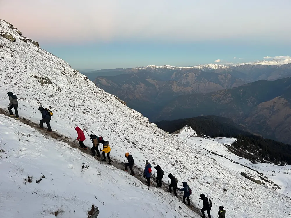 Hikers climbing a snowy mountain in winter gear
